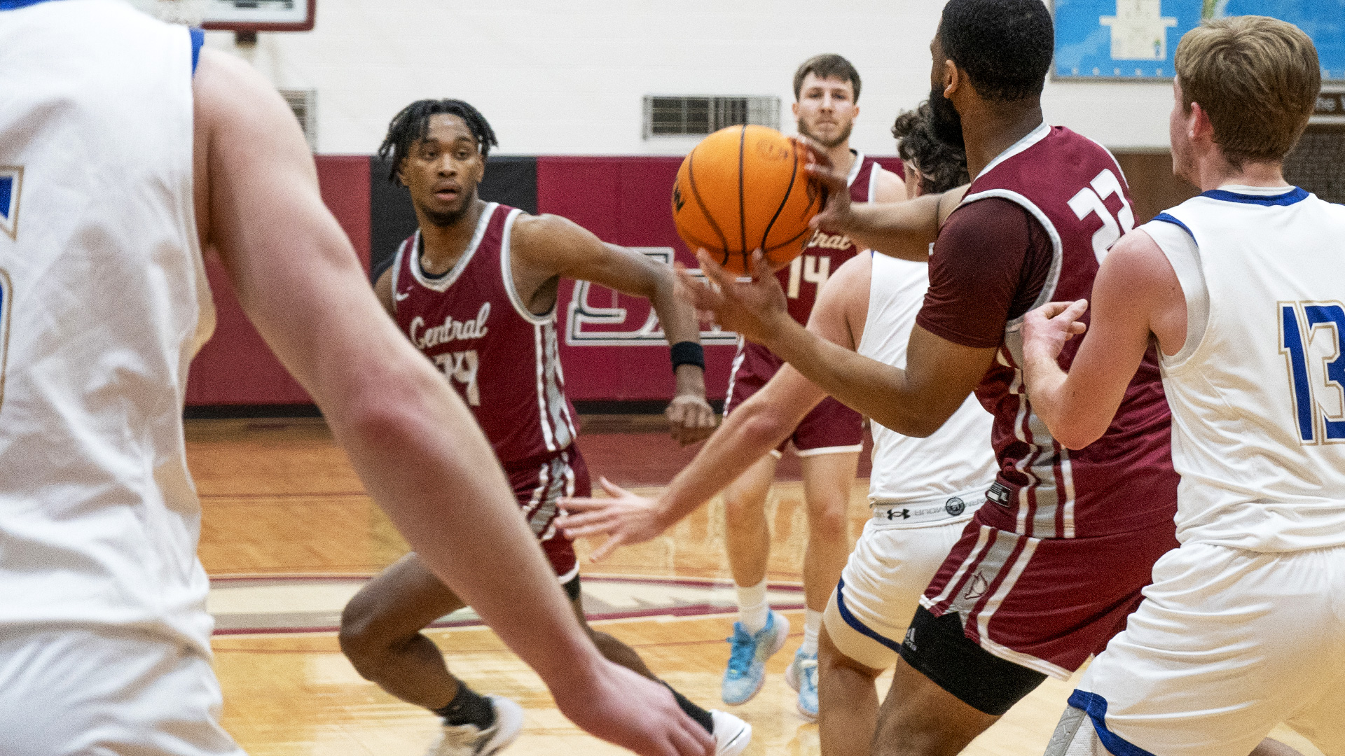 CCCB senior guard Sam Adams looks for a cutting Quincy James, Jr., during the Saints' 80-79 win over the Eagles on Saturday.